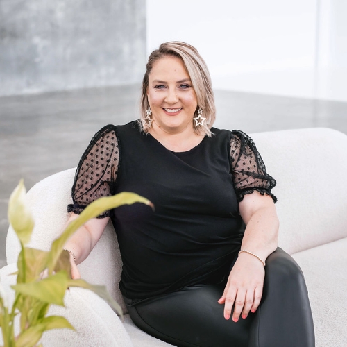 Diana Todd, Tax Accountant and founder of Balance Tax Accountants, seated on a couch, leaning with her right hand resting on the couch, wearing a black outfit.